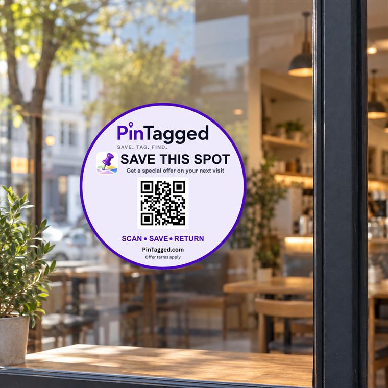 Example PinTagged partner sticker displayed on a café window, reading “Save this spot — get a special offer on your next visit”